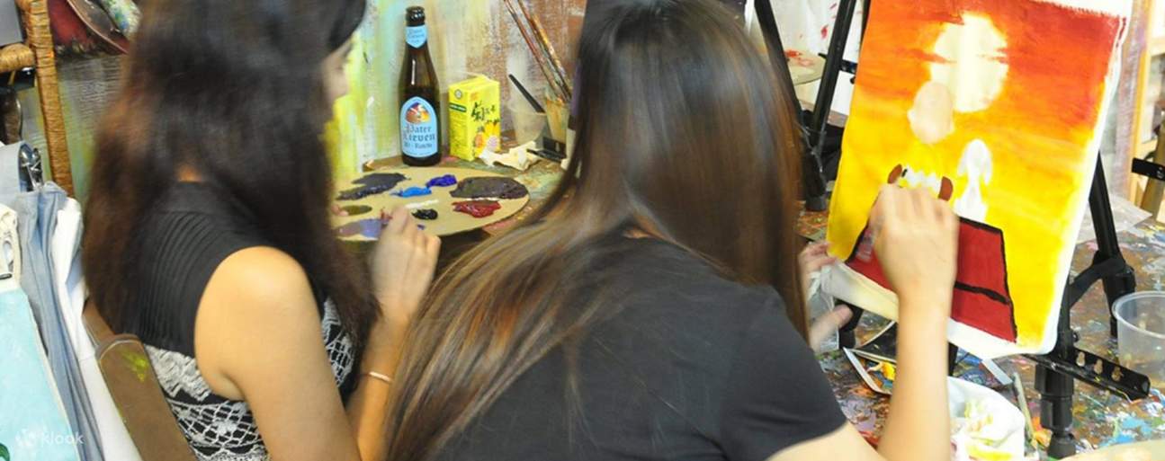 Dos chicas pintando bolsas de mano en Aura Art Causeway Bay